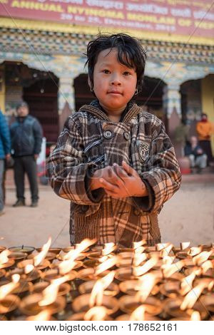 KATHMANDU, NEPAL - DEC 18, 2015: Unidentified small boy prayer near Boudhanath Stupa in Kathmandu, Nepal., Boudhanath is one of the largest ancient stupa in the world