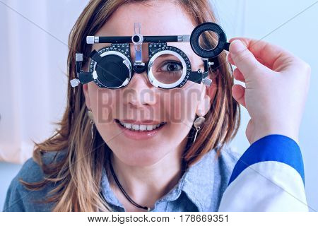 Girl woman in messbrille glasses in ophthalmology clinic. Ophthalmic glasses for diopter detection.