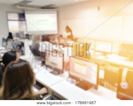 Education Concept On Blurred Students In Computer Room With Teachers. Classroom Learning With Techno