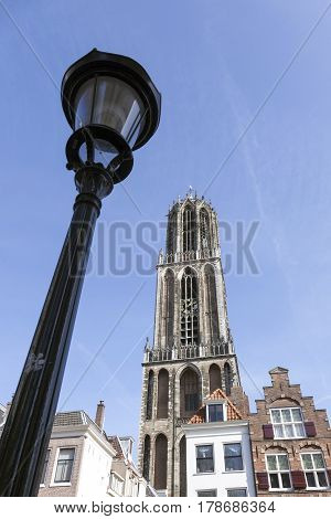 dom tower in dutch town of utrecht in the netherlands and lamp post against blue sky