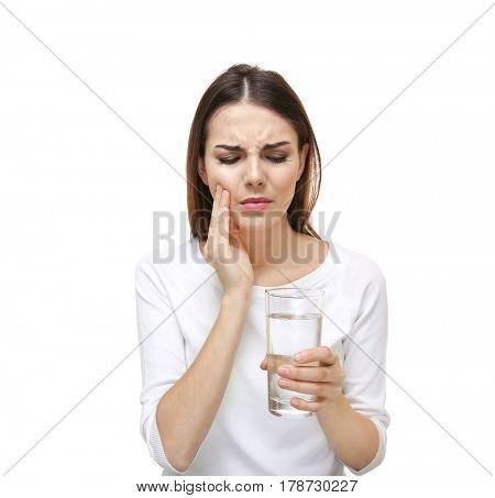 Beautiful young woman with medicine  suffering from toothache on white background