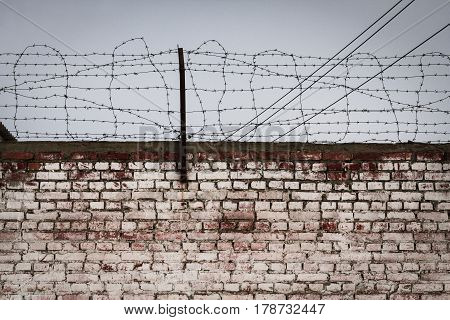 Aged and shabby brick wall and a barbed wire