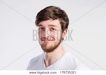 Handsome hipster fitness man in white t-shirt. Studio shot on gray background.