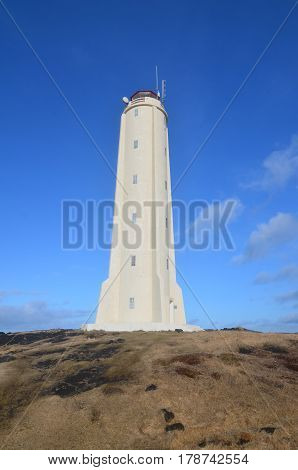 White Malarrif Lighthouse against a dark blue sky in Iceland.