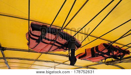 Orange Life Jacket Or Life Vest Hanging On The Roof Boat. Boat Capsized Concept.