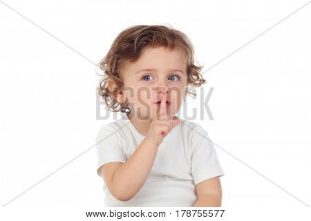 Cute baby has put forefinger to lips as sign of silence, isolated on a white background