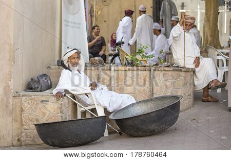 Nizwa Oma 24th March 2017: old Omani man selling old copper cooking dishes at the market