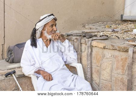 Nizwa Oma 24th March 2017: old Omani man selling old copper cooking dishes at the market