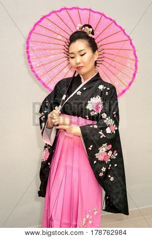 beautiful geisha in traditional japanese kimono with parasol