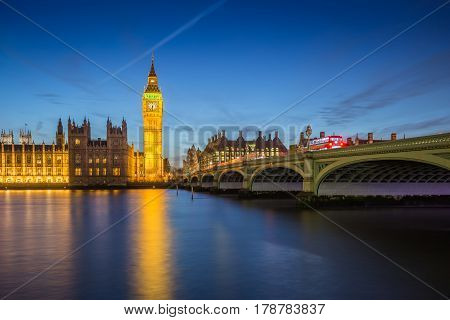 London England - The Big Ben Clock Tower and Houses of Parliament with iconic red double-decker buses at city of westminster by night