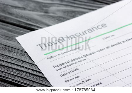 Travel preparation concept with insurance application form on wooden table background