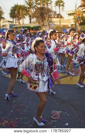 ARICA, CHILE - FEBRUARY 10, 2017: Female members of a Caporales dance group in ornate costumes performing at the annual Carnaval Andino con la Fuerza del Sol in Arica, Chile.