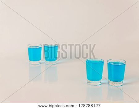 Four Glasses Of Blue Kamikaze, Glamorous Drink, Mixed Drink Poured Into Shot Glasses