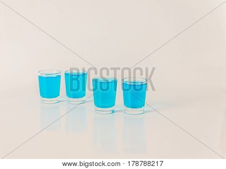 Four Glasses Of Blue Kamikaze, Glamorous Drink, Mixed Drink Poured Into Shot Glasses