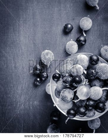 Frozen And Fresh Berries In A Glass Pial On A Black Background.