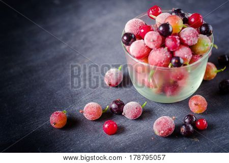 Frozen And Fresh Berries In A Glass Pial On A Black Background.