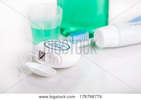 Dental Floss Focused With  Toothbrush, Toothpaste, Mouthwash, At Background