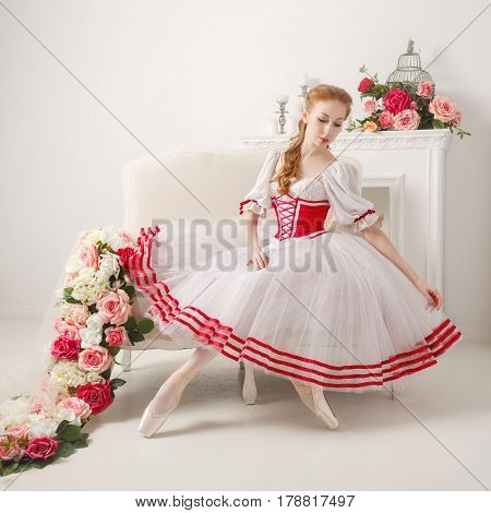 Sweet ballerina in a stage suit straightens her skirt next to bouquets of spring flowers. Retro dress.