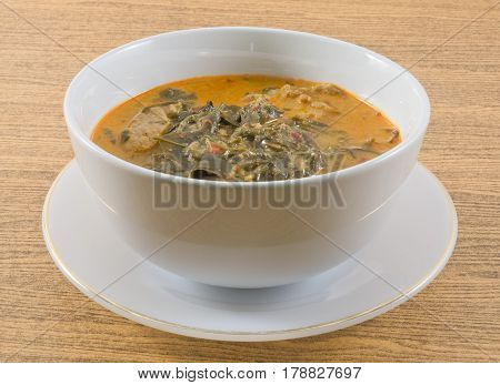 Thai Cuisine and Food A Bowl Thai Spicy Creamy Coconut Milk Curry with Cassia Leaves and Grilled Beef Fillet.