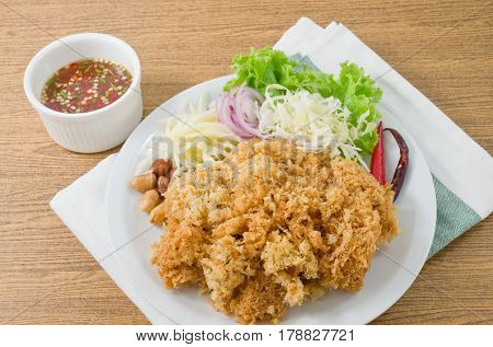 Thai Cuisine and Food Thai Traditional Crispy Catfish Salad Served With Green Oak Shredded Green Mango Red Onion Cabbage Chili Peanut and Spicy Sauce.