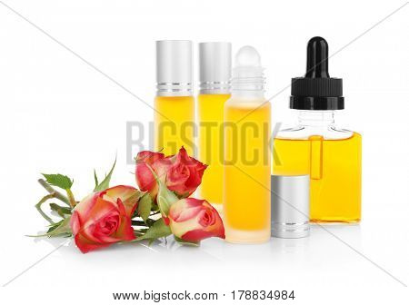 Bottles with perfume and rosebuds on white background