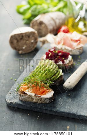 Tasty rye bread sandwiches with salmon, avocado, beetroot, creamcheese, ham, herbs and spices