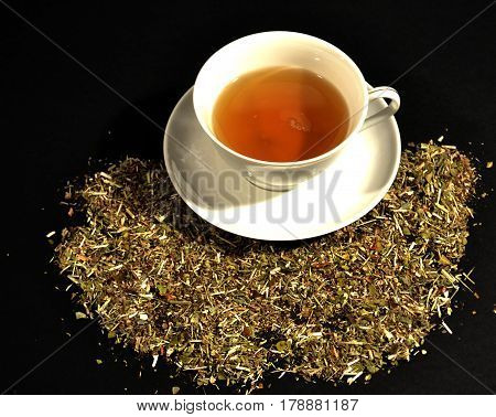 cup of tea and herbs on a wooden Net Worth on a black background