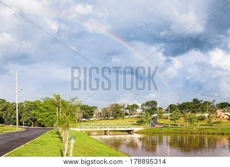 Sunny Afternoon At Park After Rain With A Beautiful Rainbow On Background