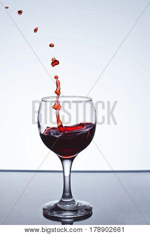 moving red wine glass over a white background on a white background freezing