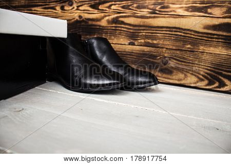 the boots and shoes box on wooden background