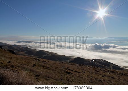 Clouds Covering a Mountain Valley at Sunrise with a Sunburst
