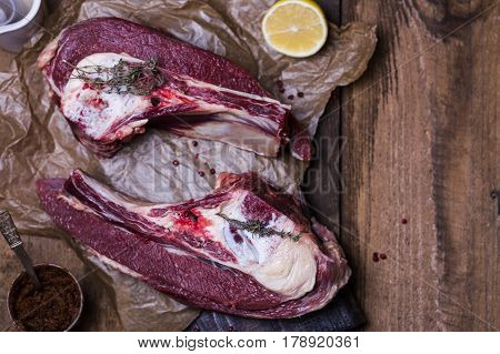 Fresh raw beef bone rib with spices on wooden background