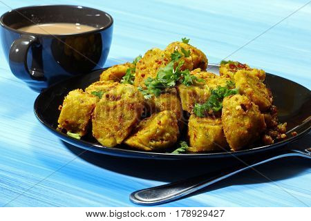 Dry gatte ki sabji or Dhoka made of chick pea flour and spicy masala on a blue wooden background.