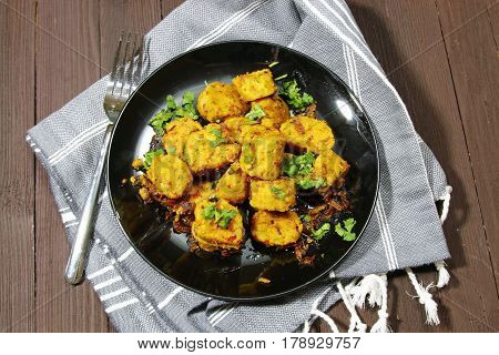 Overhead view of dry Gatte ki sabji or Dhoka made of chickpea flour or Besan with onions and ginger and other Indian spices.