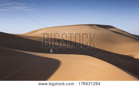 young man walking in sand dunes in Liwa desert in Abu Dhabi