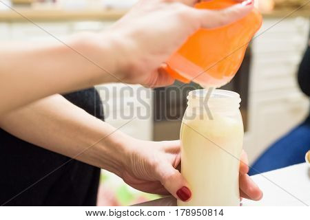 Close up of woman preparing baby food in bottle