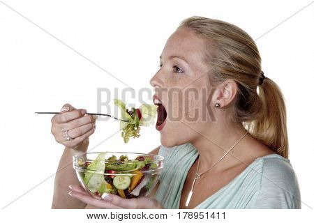 a young woman eating a crunchy salad at lunchtime. healthy diet with vitamins.