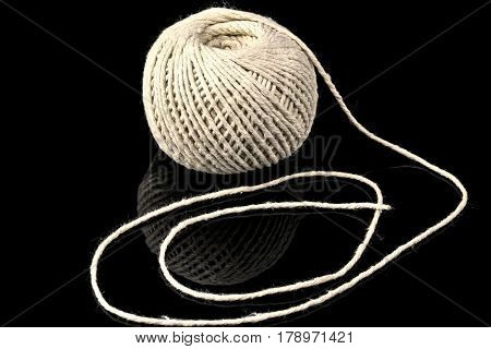 Curved thick string and an roll on black background.