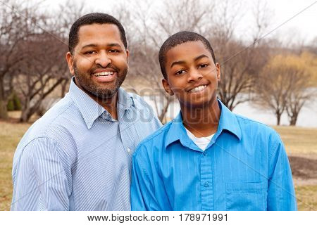 Happy African American father and his teenage son.
