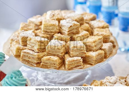 Stack of square bakery slices desserts or cakes on plate closeup