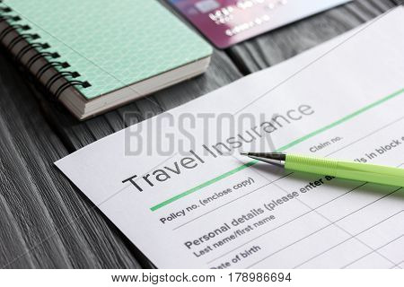 Travel preparation concept with insurance application form and credit cards for online payment on wooden table background