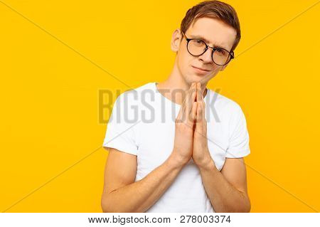 A Cunning Man, A Man With Glasses, In A White T-shirt, With A Mysterious Smile, Looks Into The Camer