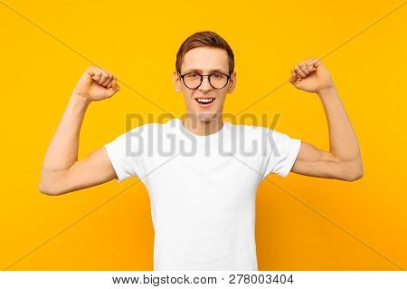 Man In Glasses, Dressed In A White T-shirt, The Man Who Won Shows A Gesture Of Victory And Success,