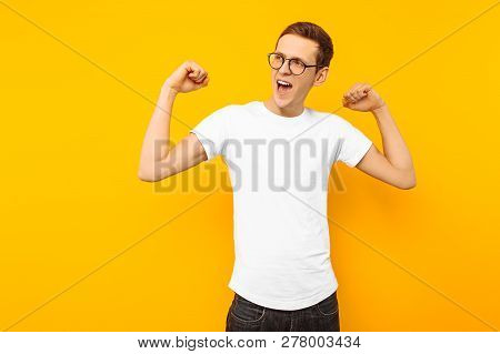 Man In Glasses, Dressed In A White T-shirt, The Man Who Won Shows A Gesture Of Victory And Success,