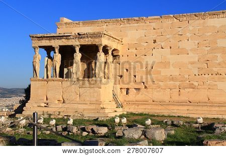 Caryatid Statues On The Porch Of The Erechtheion On The Acropolis In Athens, Greece With Blue Sky An
