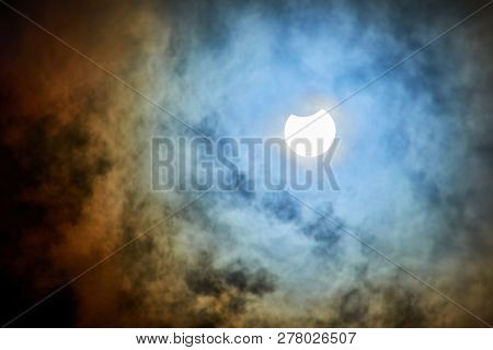 Solar Eclipse On A Cloudy Day.
Partial Solar Eclipse Viewed Under Cloudy Skies.