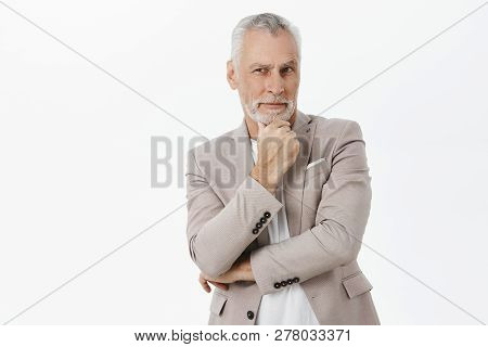 Elegant Handsome And Charismatic Male In Suit With Grey Hair And Wrinkles Holding Hand On Chin In Th