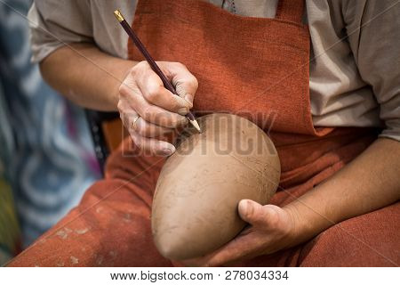 Ceramic Workshop, The Master Puts Otnament On Unfired Earthenware Jug. Close-up Of Master Hands. Mad