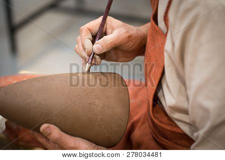 Ceramic Workshop, The Master Puts Otnament On Unfired Earthenware Jug. Close-up Of Master Hands. Mad