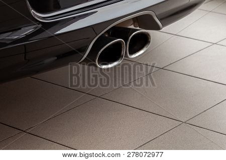 New Shiny Chrome Pipes Close-up After Tuning And Installation On The Back Of A Black Car In The Tail